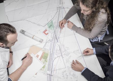 people diskussing developing blueprint on table