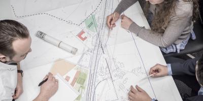 people diskussing developing blueprint on table