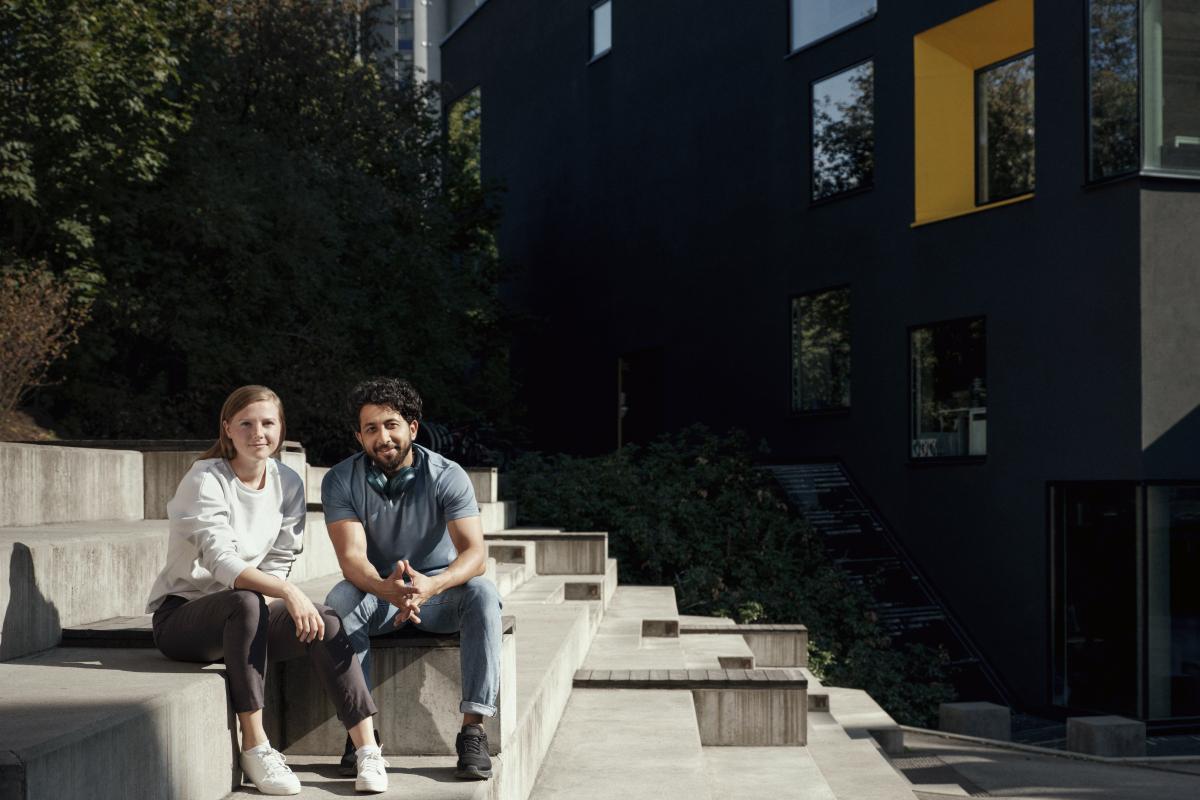 Smiling man and woman sitting on concrete steps