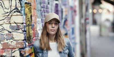 A woman stands in front of a wall 