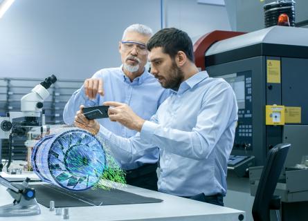Analysis Simulation two men looking at simulation through mobile device in lab