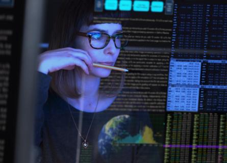 SCM 4.0 woman biting on pen looking at digital screen 