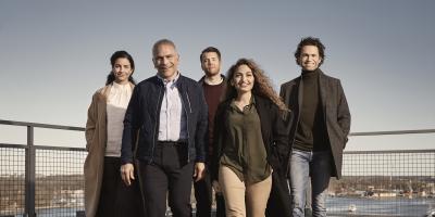 A group of five adults walking on a roof terrace