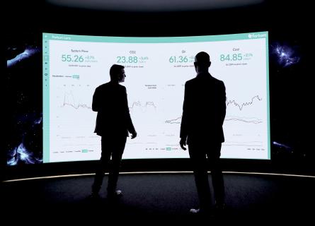 Two clients looking at dashboard on the big screen