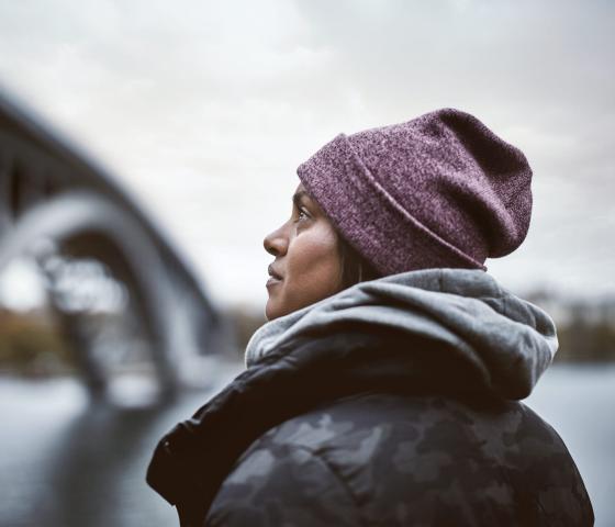 woman looking up towards a bridge