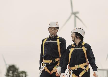 Engineers walking in front of wind turbines