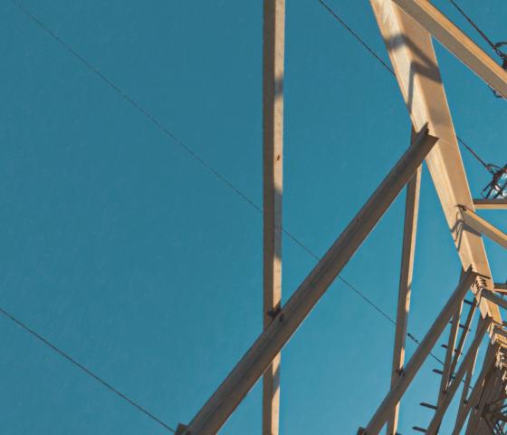 electricity pylon photographed from beneath against blue sky