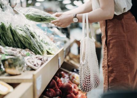 woman buying red apples and green salad in the store