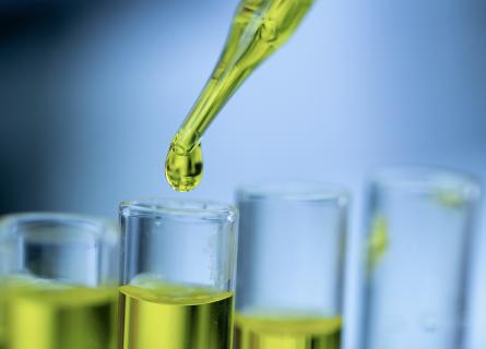 Green fluid dripping into glass tubes