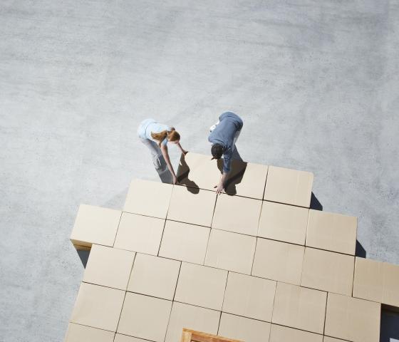 two people organize cardboard boxes logistics packaging