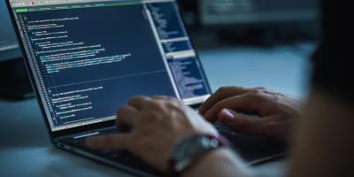 Guy writing code on a computer screen