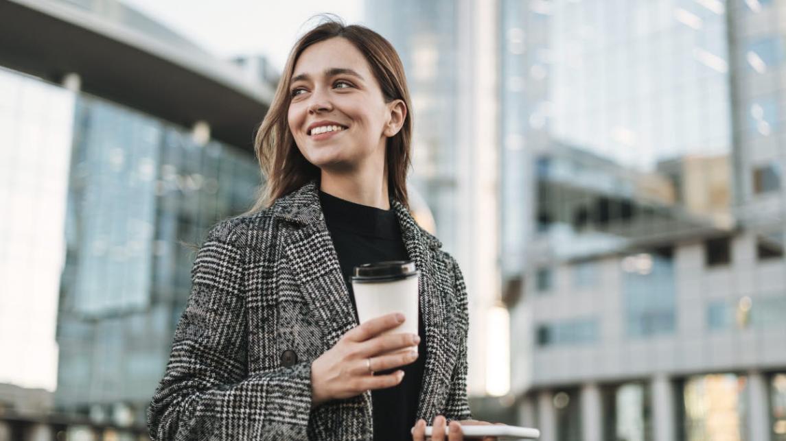 Smiling person with a coffee cup