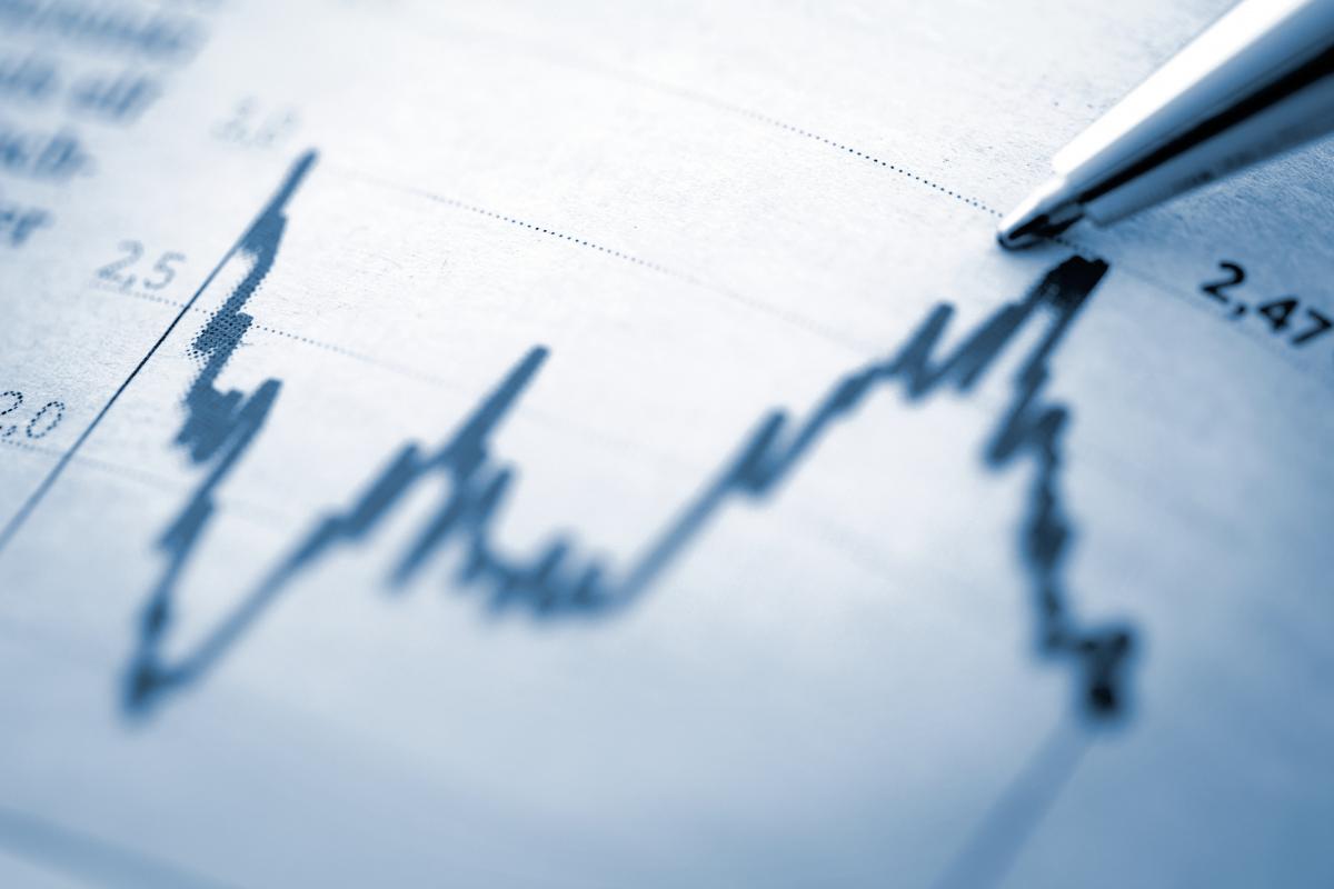 Data chart with pen pointing at peak