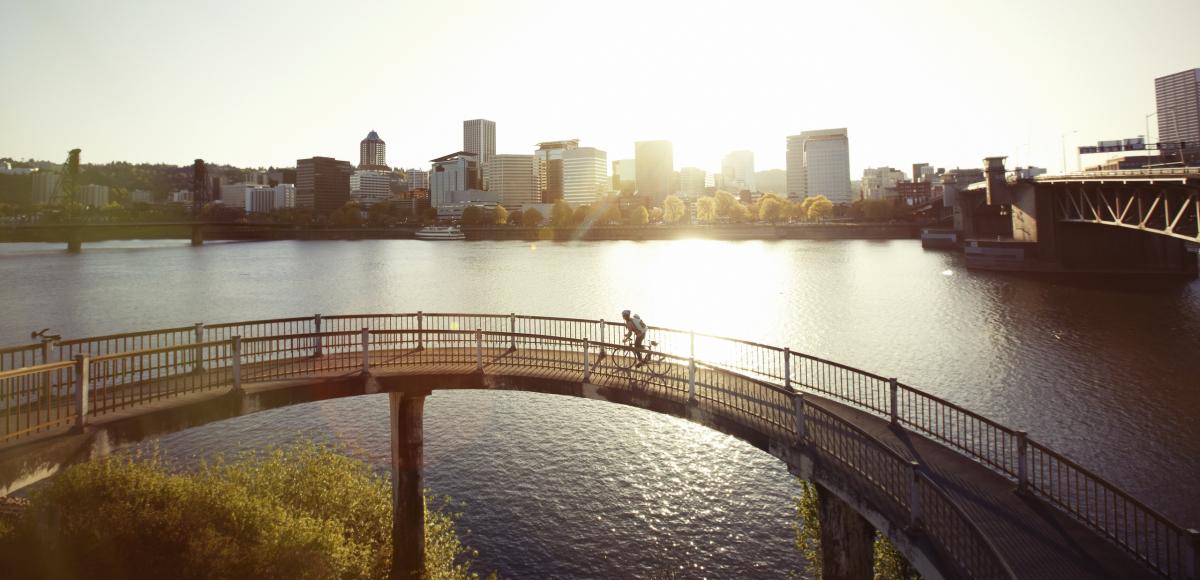 a cyclist rides over a bridge in evening light