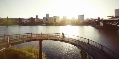 a cyclist rides over a bridge in evening light