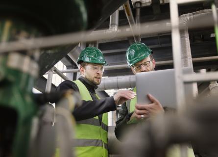 Two guys in a factory working with a tablet