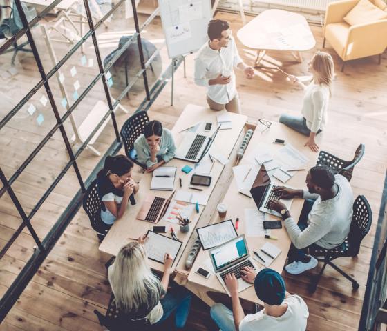 team of people working together at large office desk