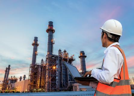 Man in work wear overlooking industrial scene
