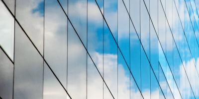 Reflection of blue cloudy sky in glass building