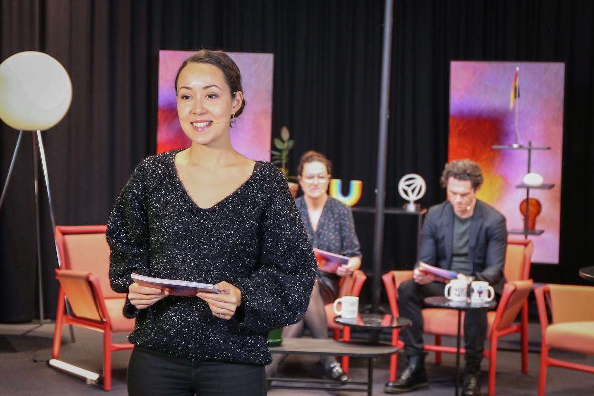 A woman stands in a studio
