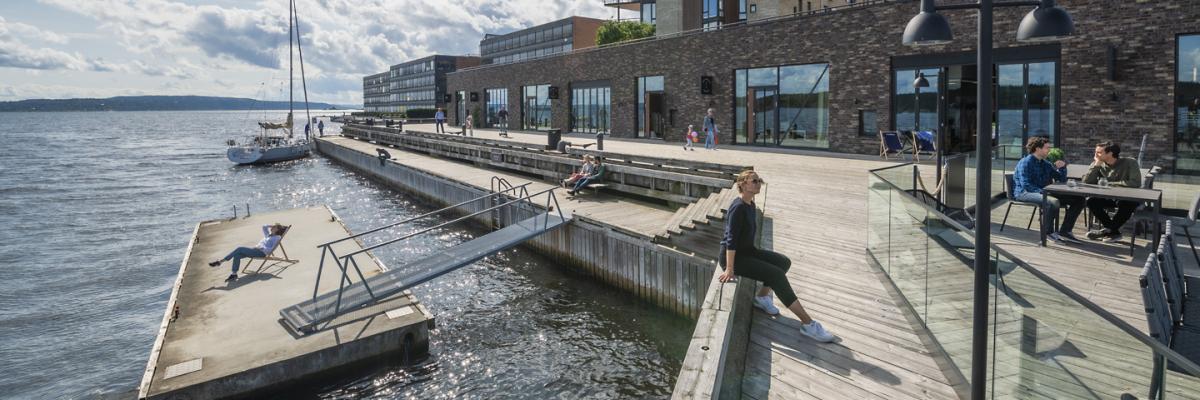 People in a quay, residential buildings at the background