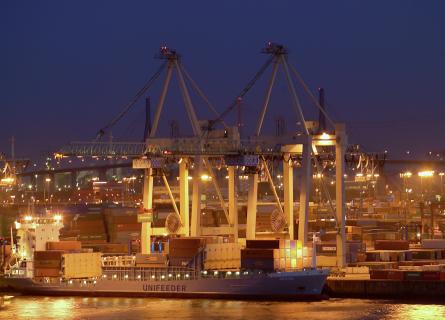 Ship in a harbour, containers and cranes at the background