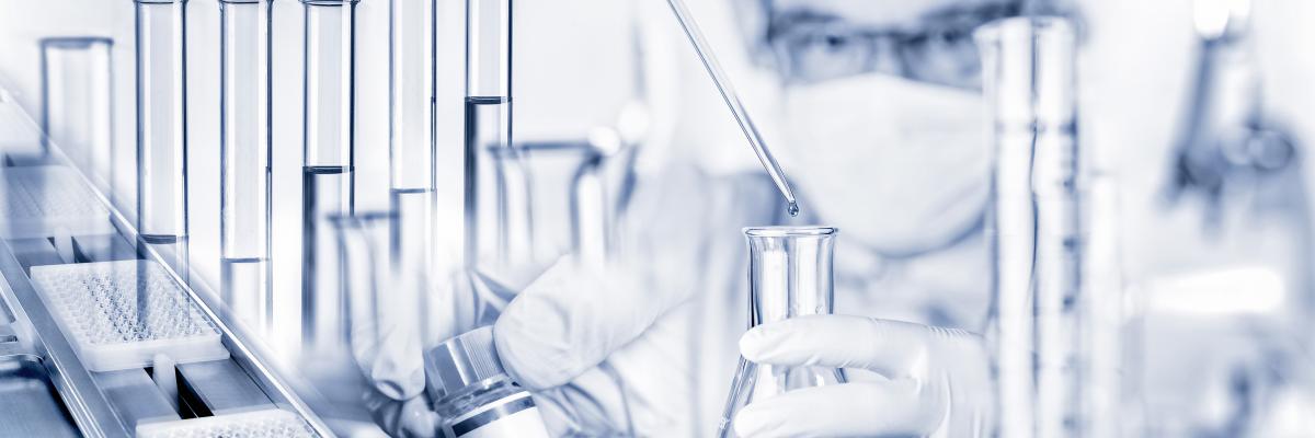 Scientist in a lab holding a glass bottle and a dropper