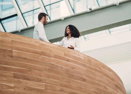  Bioeconomy experts shaking hands in cooperation behind wooden railing