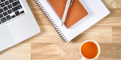 computer beside notebook and cup of tea