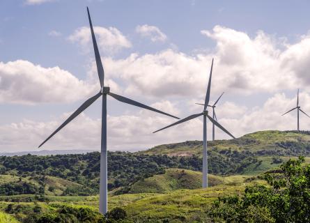 Four wind turbines on a green hilly landscape