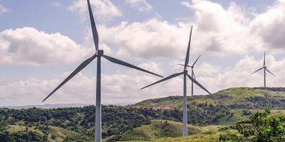 Four wind turbines on a green hilly landscape
