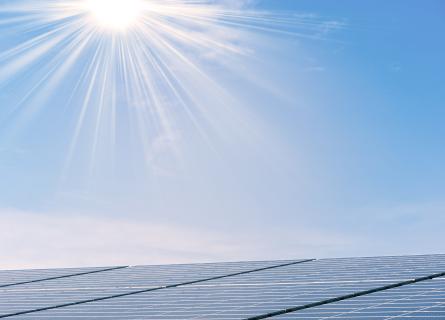 Solar panels under blue sky and sun