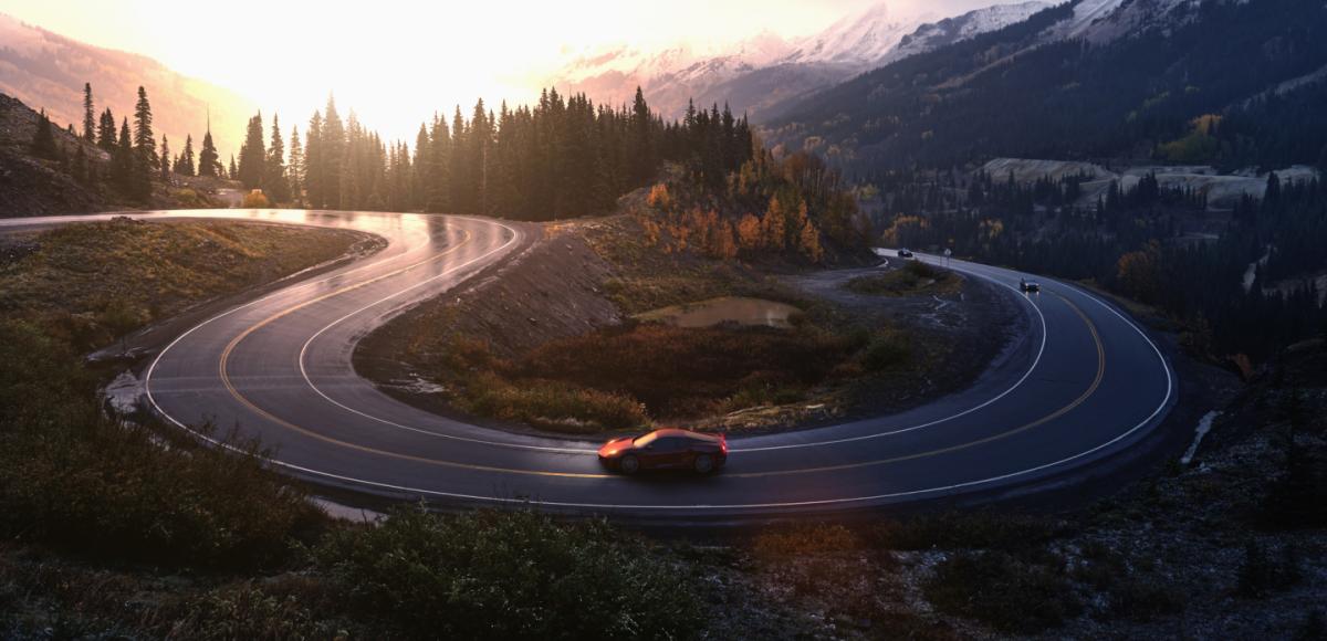 Red sports car driving on winding road