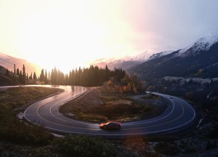 Red sports car driving on winding road