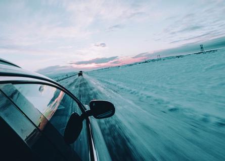car driving on lonely road during winter