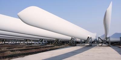 A row of wind turbine blades lying in rigs ready for installation