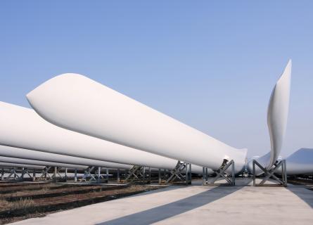 A row of wind turbine blades lying in rigs ready for installation