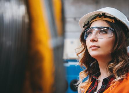 Young businesswoman white helmet googles industrial environment