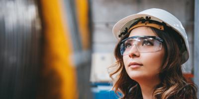 Young businesswoman white helmet googles industrial environment